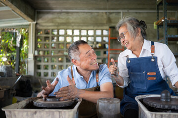 Portrait of a senior Asian couple doing activities together in the pottery workshop.