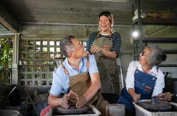 Portrait of a senior Asian couple doing activities together in the pottery workshop.