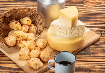 Cheese bread and cheese, a table with cheese bread and pieces of cheese and a cup of coffee on a rustic table, selective focus.
