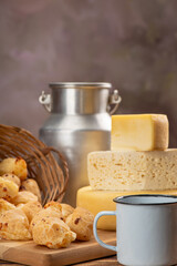 Cheese bread and cheese, a table with cheese bread and pieces of cheese and a cup of coffee on a rustic table, selective focus.