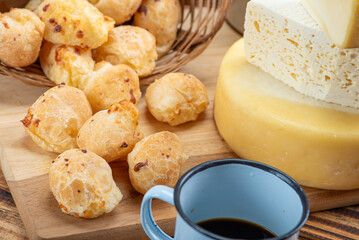 Cheese bread and cheese, a table with cheese bread and pieces of cheese and a cup of coffee on a rustic table, selective focus.