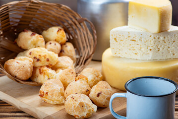 Cheese bread and cheese, a table with cheese bread and pieces of cheese and a cup of coffee on a rustic table, selective focus.