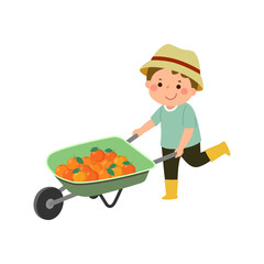 Little boy gardener pushing wheelbarrow full of oranges