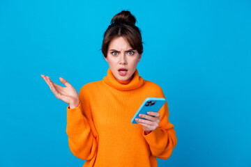 Photo of shocked impressed woman dressed orange sweater getting dislikes modern gadget isolated...