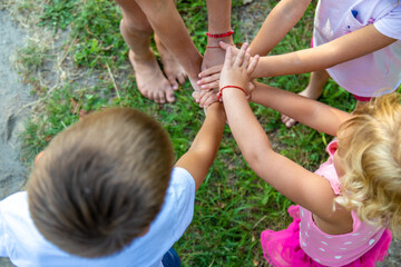 a group of children stand together in a circle and fold their hands, team spirit before the game.