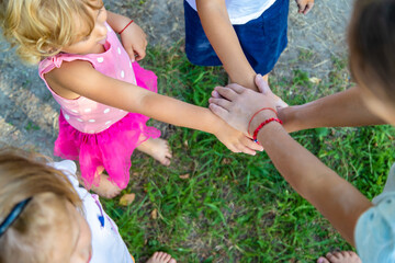 a group of children stand together in a circle and fold their hands, team spirit before the game.