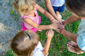 Fototapeta premium a group of children stand together in a circle and fold their hands, team spirit before the game.