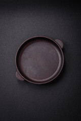 Bumpy empty ceramic plate on a textured concrete background