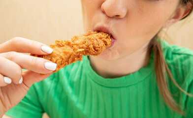 Closeup of woman eating chicken fillet