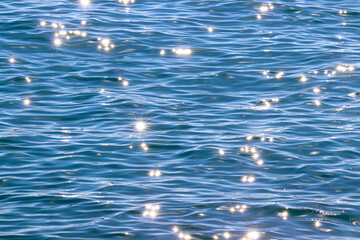 Textura de agua de mar con destellos de luz. Mar azul y brillos solares.