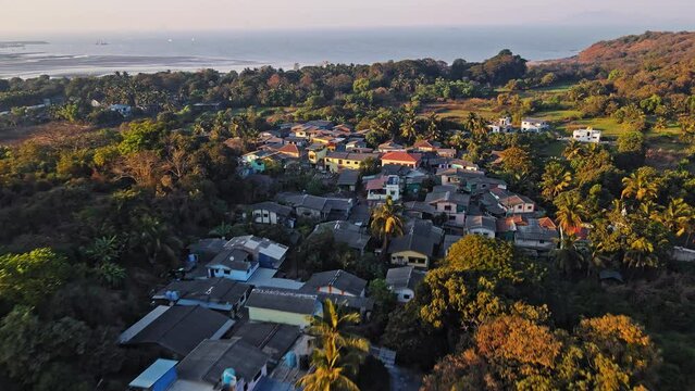 Cinematic Aerial shot of a beautiful Village Mandwa near Alibuag captures the top traditional homes and the surrounding coconut trees. 