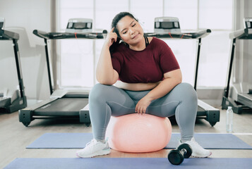 plus size women thinking question pose, asian fat femle sitting in sport club fitness studio