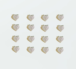 A repetitive pattern made of silver hearts against white background. Minimal concept of love. Flat lay. Valentine’s card pattern.