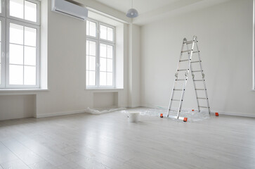 Empty unfurnished room with ladder and paint bucket. Unfinished living room interior with white walls, floor and windows. Renovation. Repairs in apartment. Empty interior space - obrazy, fototapety, plakaty