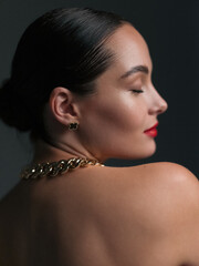 Portrait of young beautiful woman with chain in her neck and with closed eyes.