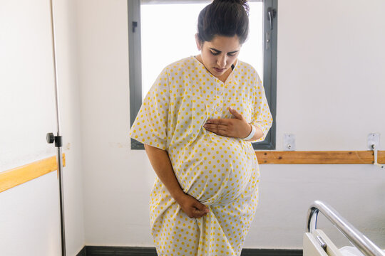 Woman with heavy pregnancy in delivery gown at hospital