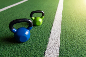Kettlebells on a grass floor in the gym.