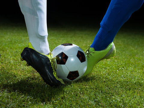 soccer player doing kick with ball on football stadium field isolated on black background