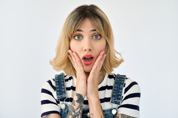 Shocked pretty gen z blonde young woman, surprised 20s girl with short blond hair and tattoos looking at camera feeling amazed or excited emotion isolated on white background. Close up face portrait. - obrazy, fototapety, plakaty