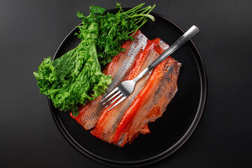 Red fish fillet on a dark background. Lightly salted fish