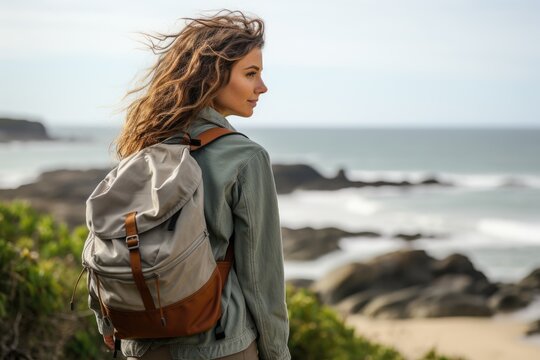A woman with a backpack looking out at the ocean