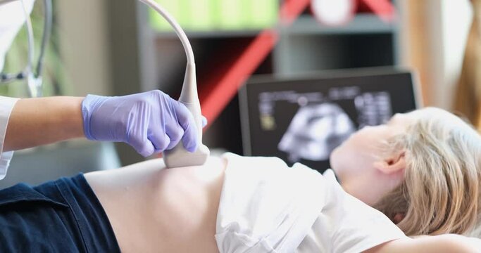 Doctor conducts ultrasound examination of internal organs of child in clinic closeup. Comprehensive screening study of child concept