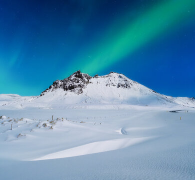 Aurora Borealis. Northern lights and starry skies. Nature. Scandinavian countries. Snow and ice on the mountains. Landscape in winter time. Photo for background and wallpaper.
