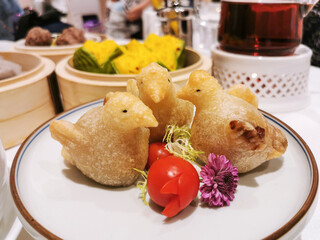 Dimsum details - fried glutinous rice balls with fillings made in cute little bird shape on plate.