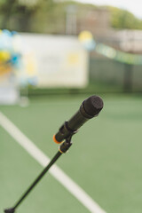 Microphone on table side sport field in stadium for commentator. Microphone for commentator with sport football field stadium background with space for text