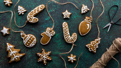 An assortment of decorated gingerbread cookie ornaments with twine.