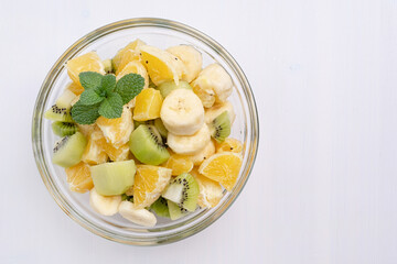 Bowl of healthy fresh fruit salad on white background