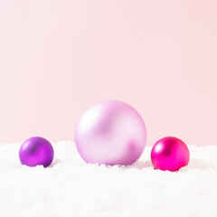 Brilliant party decorations in the snow. Pastel pink background. Minimal Christmas, New Year, birthday, Valentines, holiday concept. Copy space.