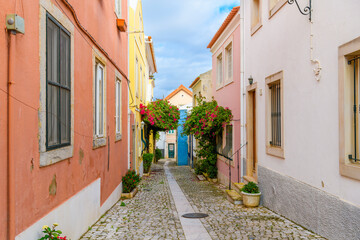 Fototapeta na wymiar A picturesque and colorful narrow cobblestone alley in the old town district of the seaside resort town of Cascais Portugal.