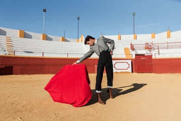 Hispanic bullfighter waving red cloth
