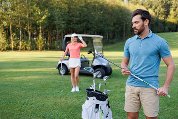 Obraz premium Greenside Leisure: Couple Delighting in Golfing Session