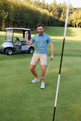 Obraz premium Golfer by the Final Hole with Golf Cart and Club