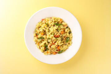 Upma made of samolina or rava upma, most famous south indian breakfast item which is arranged in a black plate and garnished with fried cashew nut and curry leaves 