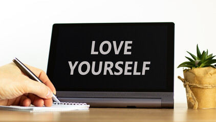 Love yourself symbol. Concept words Love yourself on beautiful black tablet. Beautiful white background. Psychologist hand. Psychology love yourself concept. Copy space.