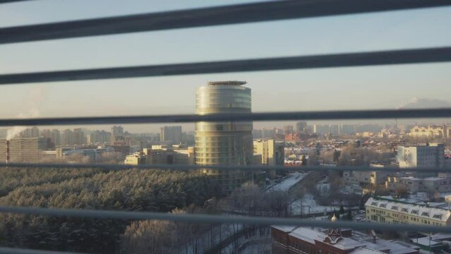 View from the window with jalousie to the winter city landscape