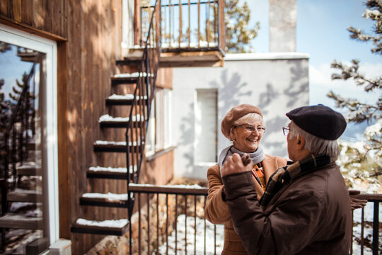 Romantic senior couple holding hands dancing in winter backyard