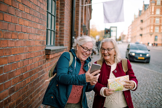 Two senior women looking for direction in the city
