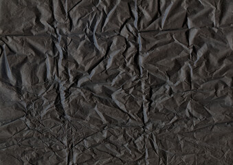 The texture of dark crumpled paper. Minimalistic background. Charcoal paper backdrop. Mysterious...