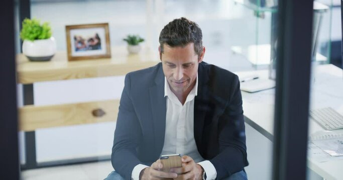 Computer, phone and a business man in a glass office for communication, networking or a text message. Technology, smile and a happy mature corporate professional in the workplace for social media