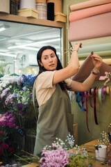 young woman florist making bouquet fresh flowers, flower shop business