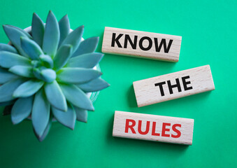 Know the rules symbol. Wooden blocks with words Know the rules. Businessman hand. Beautiful green...