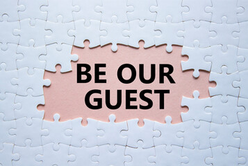 Be our guest symbol. Concept words Be our guest on white puzzle. Beautiful pink background....