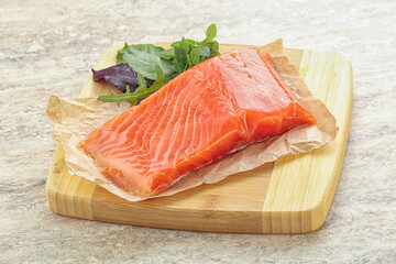 Raw salmon fillet over board