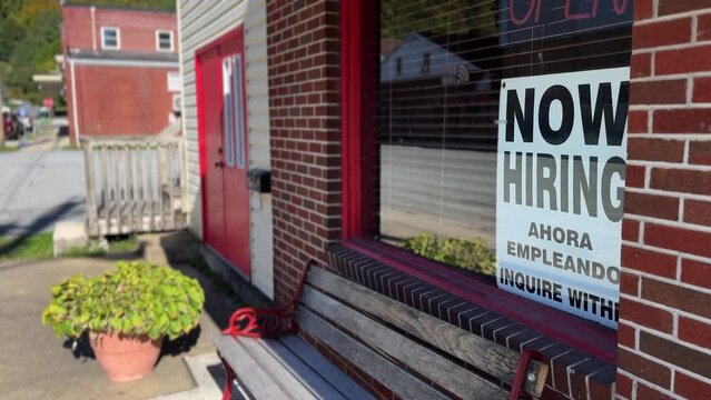 Now Hiring, Help Wanted sign on Mexican restaurant window by side of a rural West Virginia road in summer.