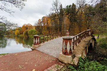 Obraz premium Stone bridge across the lake in the autumn Tsaritsyno park, Moscow, Russia