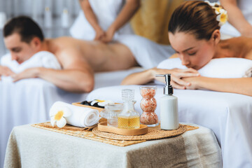 Obraz na płótnie Canvas Aromatherapy massage on daylight ambiance or spa salon composition setup with focus decor and spa accessories on blur woman enjoying blissful aroma spa massage in resort or hotel background. Quiescent